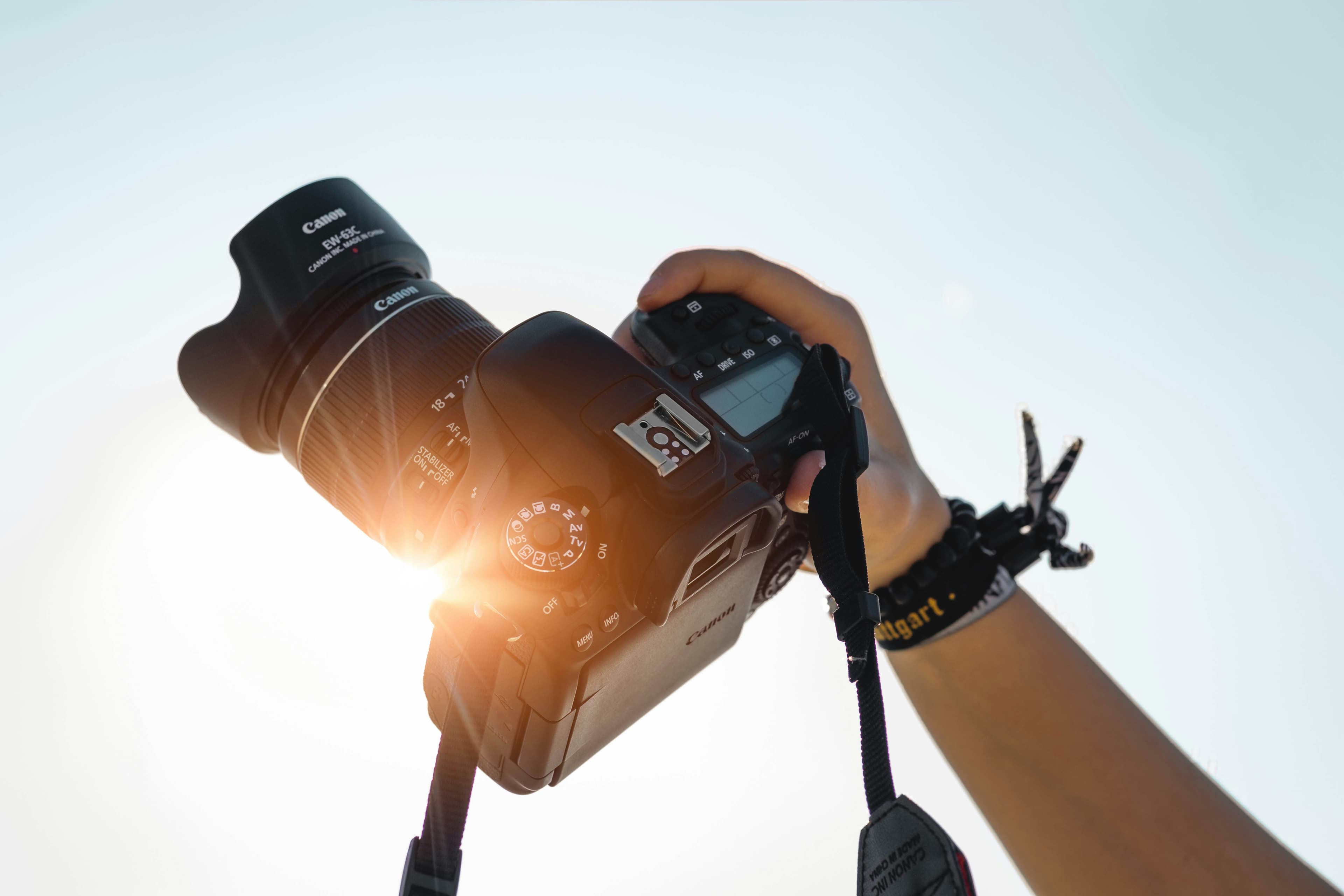 Fotograf hält seine Kamera ins warme Gegenlicht